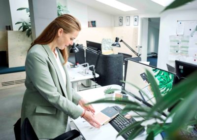 Junge Frau beim Lesen einer Stellenanzeige mit Benefits im Büro