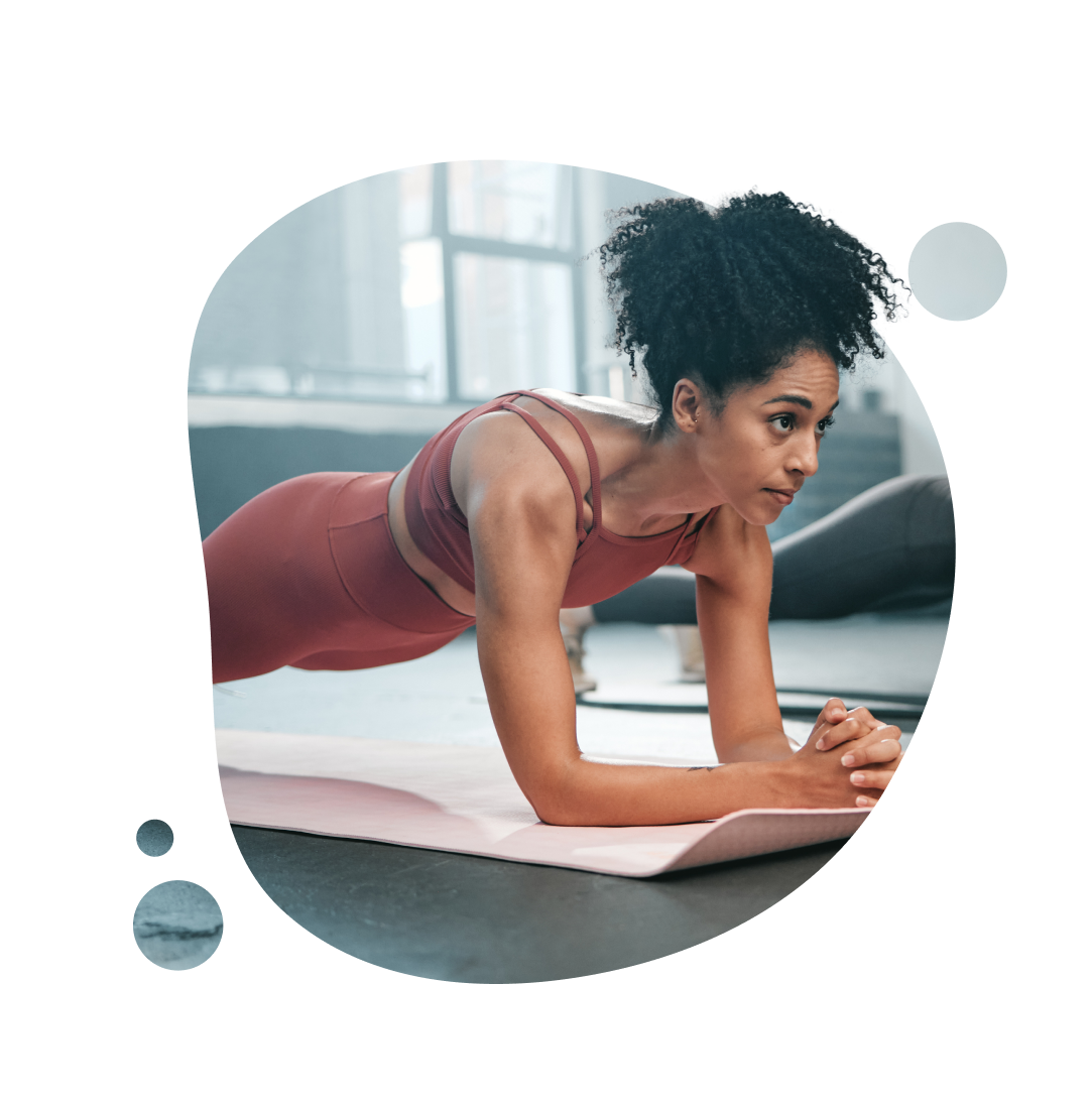 Eine Person plankt beim SPort auf einer Fitnessmatte